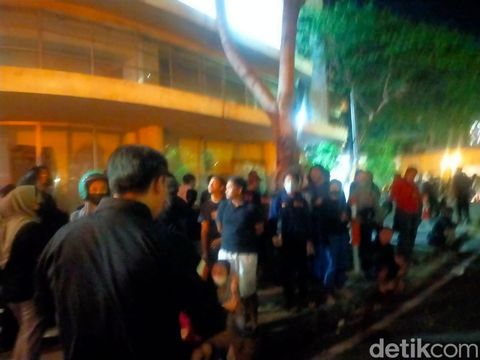 Petugas membubarkan warga yang menonton proses pembasahan TP 5 terbakar