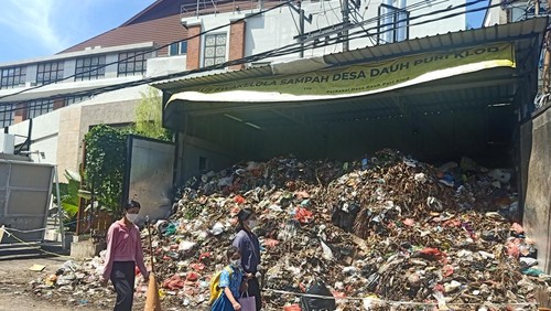 Beberapa orang tampak melewati Swakelola Sampah Desa Dauh Puri Klod yang berada tepat di belakang Level 21 Mall Denpasar pada Rabu, 13 April 2022