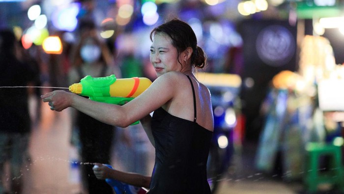 People play with water as they celebrate during the Songkran holiday which marks the Thai New Year during the coronavirus disease (COVID-19) outbreak, in Bangkok, Thailand, April 13, 2022. REUTERS/Soe Zeya Tun