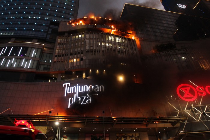 Petugas Dinas Pemadam Kebakaran Kota Surabaya memadamkan Tunjungan Plaza 5 yang terbakar di Surabaya, Jawa Timur, Rabu (13/4/2022). Sejumlah kendaraan pemadam kebakaran dikerahkan termasuk tiga Bronto Skylift untuk memadamkan api yang membakar lantai 5 Tunjungan Plaza 5 itu. ANTARA FOTO/Didik Suhartono/aww.