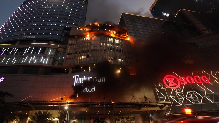 Petugas Dinas Pemadam Kebakaran Kota Surabaya memadamkan Tunjungan Plaza 5 yang terbakar di Surabaya, Jawa Timur, Rabu (13/4/2022). Sejumlah kendaraan pemadam kebakaran dikerahkan termasuk tiga Bronto Skylift untuk memadamkan api yang membakar lantai 5 Tunjungan Plaza 5 itu. ANTARA FOTO/Didik Suhartono/aww.