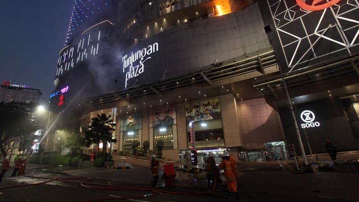 Petugas Dinas Pemadam Kebakaran Kota Surabaya memadamkan Tunjungan Plaza 5 yang terbakar di Surabaya, Jawa Timur, Rabu (13/4/2022). Sejumlah kendaraan pemadam kebakaran dikerahkan termasuk tiga Bronto Skylift untuk memadamkan api yang membakar lantai 5 Tunjungan Plaza 5 itu. ANTARA FOTO/Didik Suhartono/aww.