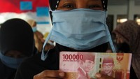 Warga menunjukkan bantuan uang saat penyaluran Bantuan Langsung Tunai (BLT) subsidi minyak goreng di Kelurahan Debong Kidul, Tegal, Jawa Tengah. (Oky Lukmansyah/Antara Foto).