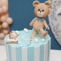 Kue baby shower milik Jessica Iskandar pun terlihat cukup unik dan lucu. Kue berwarna biru itu tampak dihiasi dengan bentuk beruang yang membawa balon dan seorang anak laki-laki yang tengah tertidur.  Foto: Instagram