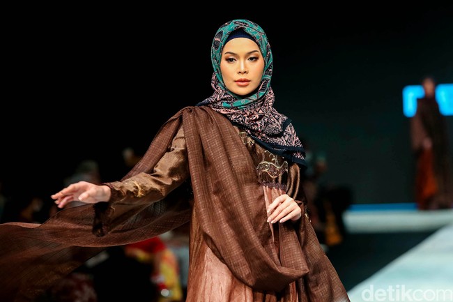 Fashion show koleksi Edyfa x Dewi Lestari menampilkan busana muslim dari kain Jambi di Indonesia Fashion Week 2022. Foto: Grandyos Zafna