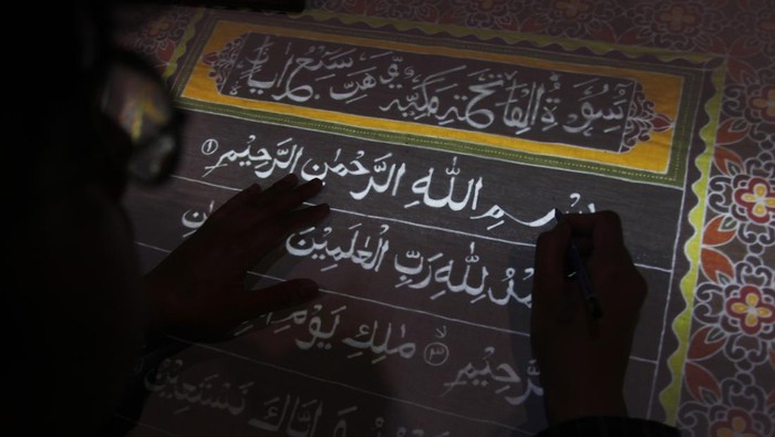 Perajin menebalkan pola untuk membuat kain batik bermotif ayat suci Al Quran di Mahkota Batik Laweyan, Solo, Jawa Tengah, Rabu (13/4/2022). Selain untuk menarik kunjungan wisatawan di kampung batik Laweyan, produk kain batik tulis bermotif ayat Al Quran tersebut dibuat sebagai mushaf untuk mengajak masyarakat belajar menulis, membaca dan memahami Al Quran. ANTARAFOTO/Maulana Surya/wsj.