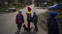 Anak-anak berjalan di Bucha di pinggiran Kyiv, Ukraina. Kematian tidak dapat dipisahkan dari Bucha. Pihak berwenang setempat mengatakan bahwa setidaknya 16 anak termasuk di antara ratusan orang yang tewas. Mereka yang selamat menghadapi pemulihan yang lama.