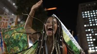 Seorang warga ikut serta dalam pesta jalanan yang digelar sebagai bentuk protes pembatasan aktivitas terkait COVID-19 di Rio de Janeiro, Brasil, Rabu (13/4/2022) waktu setempat.