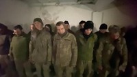 Orang-orang yang dikatakan sebagai tawanan perang berdiri dalam formasi di lokasi yang disebut sebagai Mariupol, Ukraina.