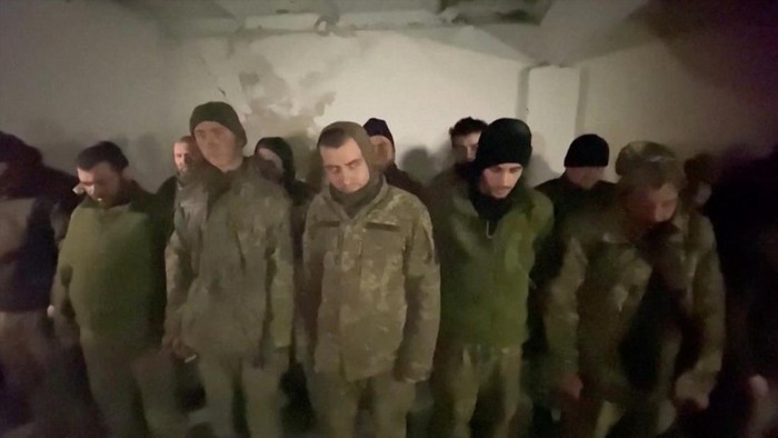 Ribuan Tentara Ukraina Menyerah Usai Dikepung Rusia di Mariupol Soldiers carry a wounded man on a stretcher as they display a white flag in a location given as Mariupol, Ukraine, in this still image taken from video that Russian TV released April 13, 2022, and says shows Ukrainian marines surrendering in Mariupol. Reuters could not independently confirm the surrender and authenticity of the Russian TV footage. RURTR/via Reuters TV/Handout via REUTERS ATTENTION EDITORS - THIS IMAGE HAS BEEN SUPPLIED BY A THIRD PARTY. NO RESALES. NO ARCHIVES. RUSSIA OUT. NO COMMERCIAL OR EDITORIAL SALES IN RUSSIA