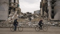 Pesepeda melintas di depan bangunan apartemen yang hancur dalam baku tembak di  Borodyanka, Ukraina, Selasa, (5/4/2022). .(AP Photo/Vadim Ghirda)