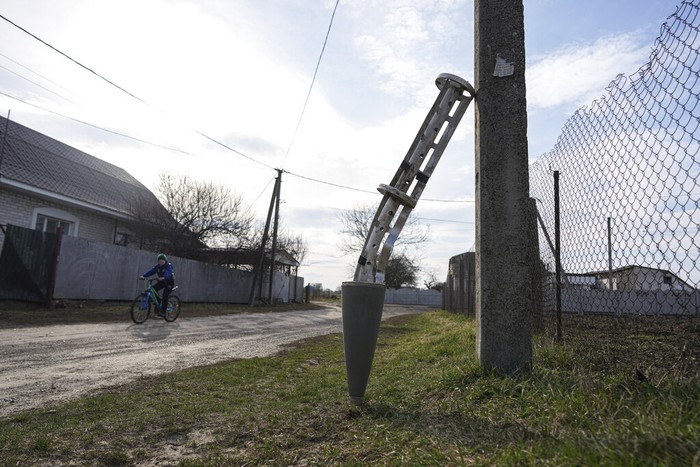 Sepeda di perang ukraina A boy rides a bicycle past a part of a missile leaning against a pole in Chernihiv, Ukraine, Thursday, April 7, 2022. (AP Photo/Evgeniy Maloletka)