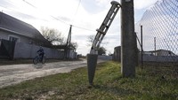 Anak kecil melintasi serpihan misil di Chernihiv, Ukraina, Kamis (7/4/2022). (AP Photo/Evgeniy Maloletka)