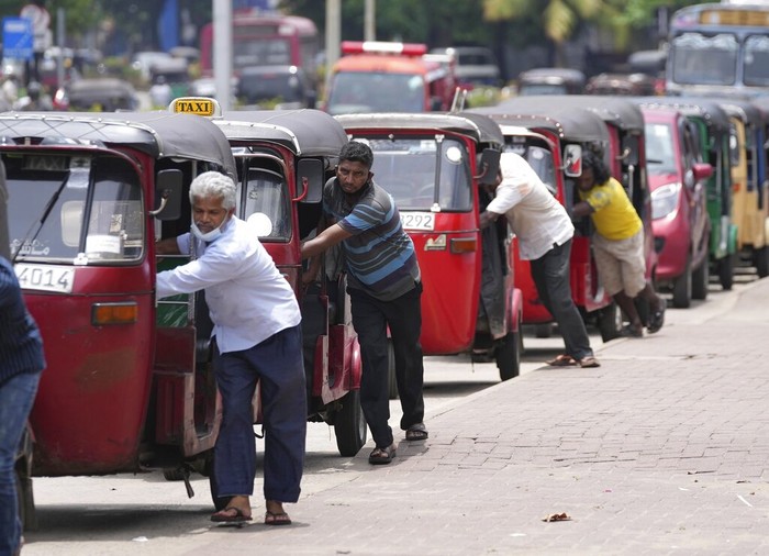 Sri Lankan auto rickshaw drivers queue up to buy petrol near a fuel station in Colombo, Sri Lanka, Wednesday, April 13, 2022. Sri Lankas prime minister on Wednesday offered to meet with protesters occupying the entrance to the presidents office, saying he would listen to their ideas to resolve the economic, social and political challenges facing the country. (AP Photo/Eranga Jayawardena)