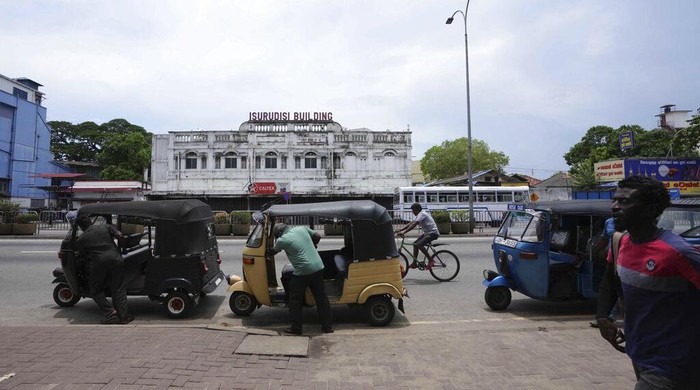 Sri Lankan auto rickshaw drivers queue up to buy petrol near a fuel station in Colombo, Sri Lanka, Wednesday, April 13, 2022. Sri Lanka's prime minister on Wednesday offered to meet with protesters occupying the entrance to the president's office, saying he would listen to their ideas to resolve the economic, social and political challenges facing the country. (AP Photo/Eranga Jayawardena)