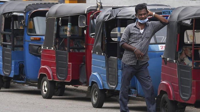 Sri Lankan auto rickshaw drivers queue up to buy petrol near a fuel station in Colombo, Sri Lanka, Wednesday, April 13, 2022. Sri Lanka's prime minister on Wednesday offered to meet with protesters occupying the entrance to the president's office, saying he would listen to their ideas to resolve the economic, social and political challenges facing the country. (AP Photo/Eranga Jayawardena)