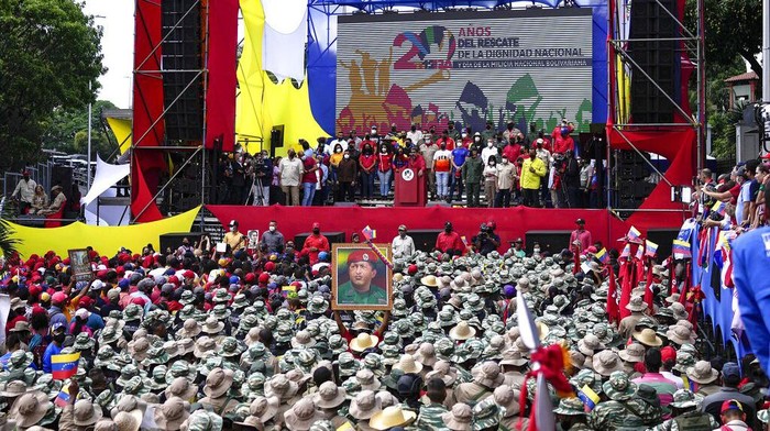Members of the Venezuelan National Bolivarian Militia, a branch of the National Armed Forces created by the late President Hugo Chavez, and supporters march commemorating the 20th anniversary of Hugo Chavez's return to power after a failed coup in 2002, in Caracas, Venezuela, Wednesday, April 13, 2022. (AP Photo/Matias Delacroix)