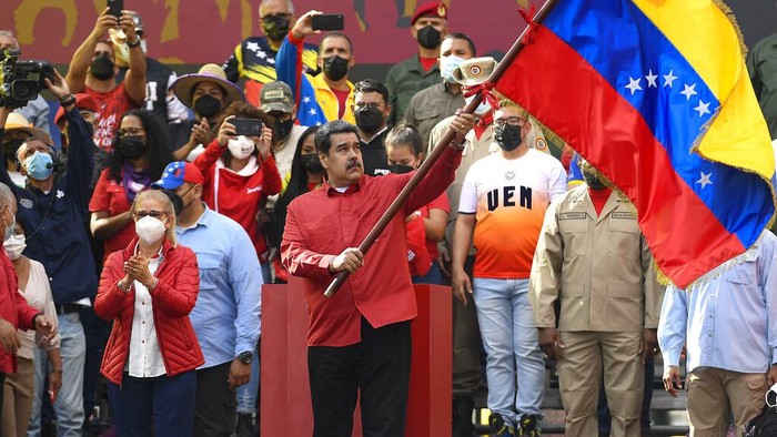 Members of the Venezuelan National Bolivarian Militia, a branch of the National Armed Forces created by the late President Hugo Chavez, and supporters march commemorating the 20th anniversary of Hugo Chavez's return to power after a failed coup in 2002, in Caracas, Venezuela, Wednesday, April 13, 2022. (AP Photo/Matias Delacroix)