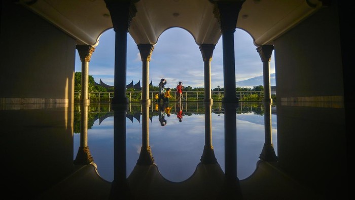 Pengunjung berjalan di taman Masjid Raya Sumatera Barat (Sumbar), di Padang, Rabu (13/4/2022). Masjid yang meraih penghargaan sebagai masjid dengan desain arsitektur terbaik di dunia dalam kompetisi Arsitektur Masjid Abdullatif Al Fozan tahun 2021 itu, ramai dikunjungi selama bulan ramadhan untuk beribadah sekaligus berwisata karena merupakan ikon wisata religi di kota itu.  ANTARA FOTO/Iggoy el Fitra/aww.