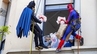 Batman dan Spiderman menuruni fasad untuk mengunjungi anak-anak yang dirawat di Klinik Anak De Marchi di Milan, Italia, Kamis (14/4/2022) waktu setempat.