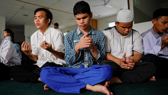 Wardah, a visually impaired student at Raudlatul Makfufin Islamic boarding school, recites the Quran written in braille while waiting for iftar during the holy fasting month of Ramadan in South Tangerang, on the outskirts of Jakarta, Indonesia, April 14, 2022. REUTERS/Willy Kurniawan