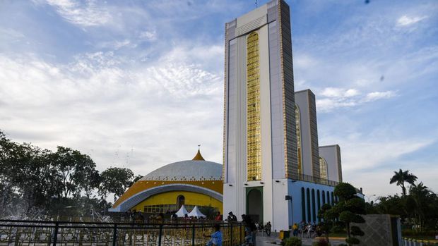 Sejumlah warga berada di halaman masjid Agung Sultan Thaf Sinar Basarsyah, Deli Serdang, Sumatera Utara, Jumat (15/4/2022). Masjid yang memadukan unsur budaya lokal dari tiga suku di Sumatera Utara yaitu Karo, Simalungun dan Melayu tersebut menjadi salah satu destinasi wisata religi yang dikunjungi umat muslim saat bulan Ramadhan 1443 H. ANTARA FOTO/Fransisco Carolio/Lmo/foc.