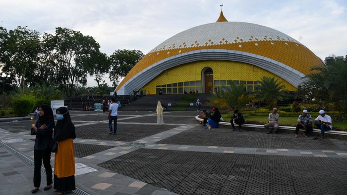 Sejumlah warga berada di halaman masjid Agung Sultan Thaf Sinar Basarsyah, Deli Serdang, Sumatera Utara, Jumat (15/4/2022). Masjid yang memadukan unsur budaya lokal dari tiga suku di Sumatera Utara yaitu Karo, Simalungun dan Melayu tersebut menjadi salah satu destinasi wisata religi yang dikunjungi umat muslim saat bulan Ramadhan 1443 H. ANTARA FOTO/Fransisco Carolio/Lmo/foc.