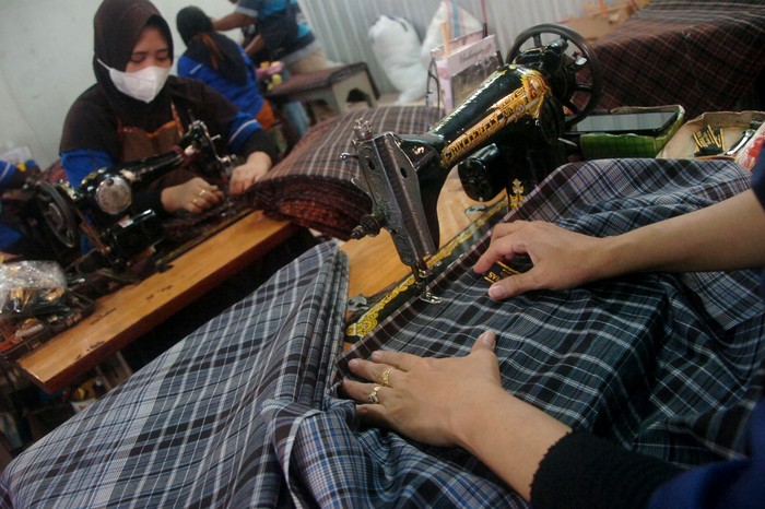 Sejumlah pekerja menata kain sarung di industri sarung Asaputex, Tegal, Jawa Tengah, Kamis (14/4/2022). Menurut pengelola sejak awal Ramadan hingga Lebaran mendatang permintaan sarung yang dijual Rp50.000 hingga Rp250.000 per potong dari dalam maupun luar kota meningkat 100 persen dibandingkan bulan sebelumnya. ANTARA FOTO/Oky Lukmansyah/foc.