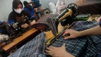 Para pekerja menjahit kain sarung dalam proses produksi di industri sarung Tegal, Jawa Tengah, Kamis (14/4/2022).