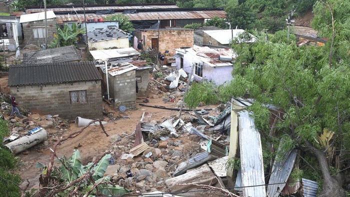 South Africa KwaZulu Natal Floods Children walk on damaged road at an informal settlement in Durban, South Africa, Thursday, April 14, 2022. Heavy rains and flooding have killed at least 341 people in South Africa's eastern KwaZulu-Natal province, including the city of Durban, and more rainstorms are forecast in the coming days. (AP Photo/Str)