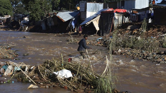 Children walk on damaged road at an informal settlement in Durban, South Africa, Thursday, April 14, 2022. Heavy rains and flooding have killed at least 341 people in South Africas eastern KwaZulu-Natal province, including the city of Durban, and more rainstorms are forecast in the coming days. (AP Photo/Str)