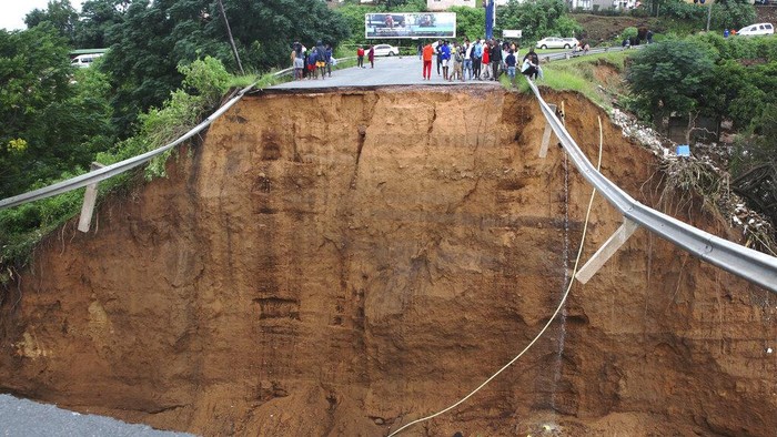 South Africa KwaZulu Natal Floods Children walk on damaged road at an informal settlement in Durban, South Africa, Thursday, April 14, 2022. Heavy rains and flooding have killed at least 341 people in South Africa's eastern KwaZulu-Natal province, including the city of Durban, and more rainstorms are forecast in the coming days. (AP Photo/Str)