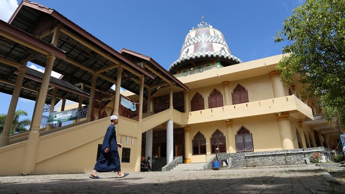 Sejumlah warga berada di lingkungan Masjid Baitul Musyahadah Desa Geuceu Kayee Jato, Banda Aceh, Aceh, Jumat (15/4/2022). Masjid Baitul Musyahadah merupakan satu-satunya masjid di Banda Aceh yang memiliki kubah berbentuk kupiah yang juga dikenal dengan sebutan Masjid Kupiah Meukeutop (topi tradisional Aceh) atau Masjid Teuku Umar. ANTARA FOTO/Syifa Yulinnas/foc.