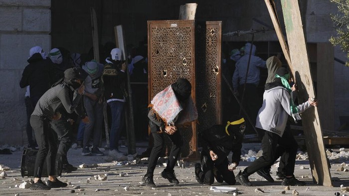Warga Palestina-Polisi Israel Bentrok Lagi di Masjid Al-Aqsa Israeli security forces take position during clashes with Palestinians demonstrators at the Al Aqsa Mosque compound in Jerusalem's Old City, Friday, April 15, 2022. (AP Photo/Mahmoud Illean)