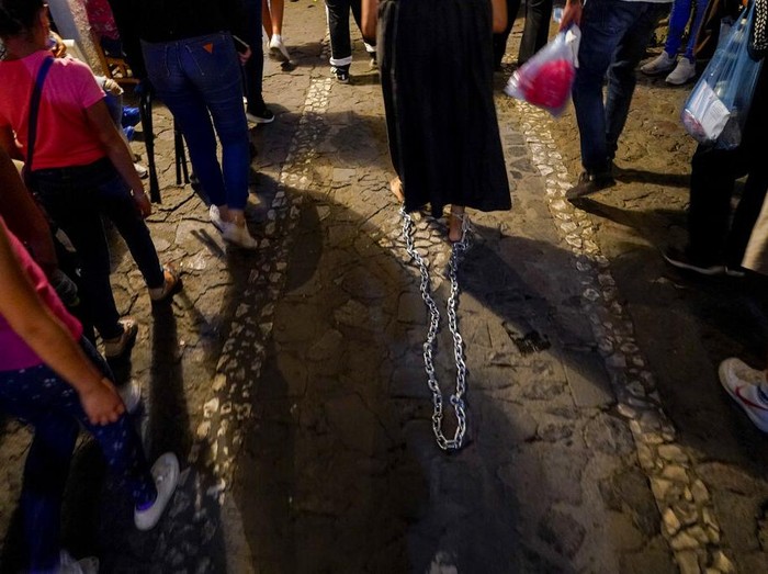 A penitent carries a bundle of thorny branches during a Holy Week procession in Taxco, Mexico, late Thursday, April 14, 2022. In traditional processions that last from Thursday evening into the early morning hours of Friday, hooded penitents drag chains and shoulder thorny bundles through the streets, as some flog themselves with nail-studded whips meant to bring them closer to God. (AP Photo/Eduardo Verdugo)