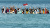 Puluhan peselancar wanita mengenakan pakaian kebaya dan mengibarkan bendera merah putih saat doa bersama di tengah laut di Pantai Kuta, Badung, Bali, Sabtu (16/4/2022).
