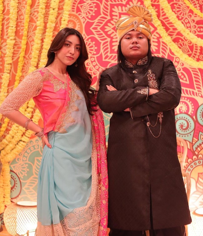 Tak hanya wanita, para teman pria Rachel juga berdandan maksimal dengan atasan ala Dhoti hingga selendang. Gaya Keanu Agl bahkan disebut mirip logo Sarimi karena sangat totalitas. Foto: Instagram