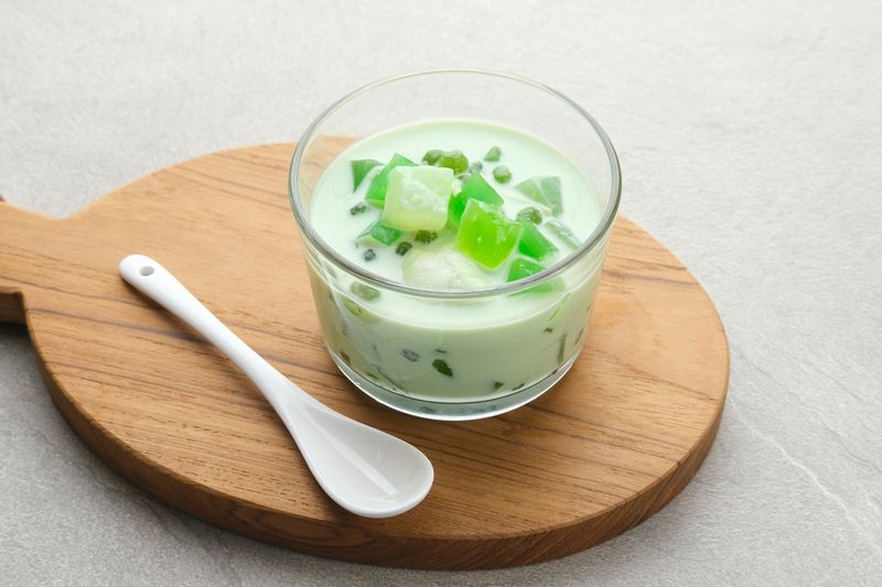 Buko Pandan, a dessert from Philippines, made from jelly, young coconut, evaporated milk, sweetened condensed milk, and ice. Served on glass. Selective focus.