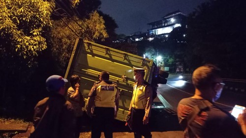 Petugas Kepolisian saat melakukan pemeriksaan di lokasi kecelakaan tunggal sebuah truk boks di Jembatan Tukad Yeh Nu, Jumat (15/4/22).