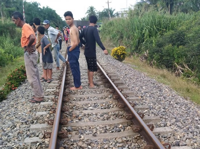 Sejumlah warga berkumpul dilokasi penemuan mayat pria yang tewas disambar Kereta Api Sri Bilah di Gunting Saga, Labura, Sumut