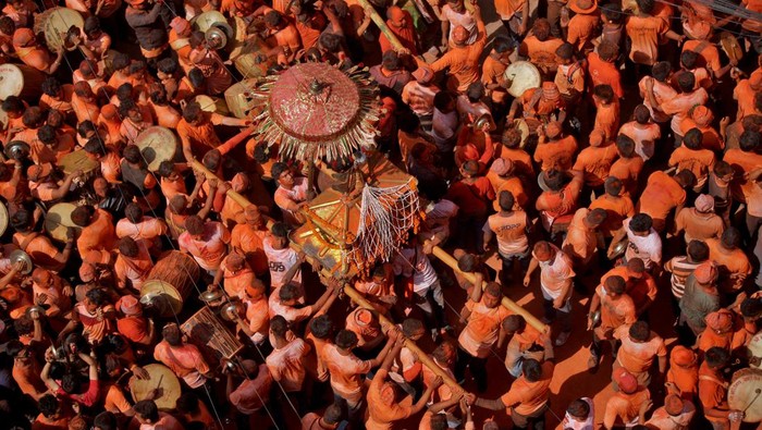 A devotee reacts as vermilion powder is applied on his face during the 