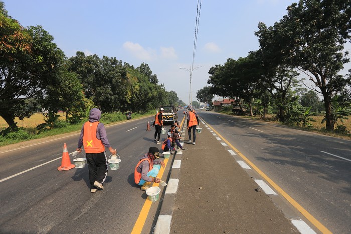 Sejumlah pekerja menyelesaikan pengecatan marka jalan di jalur pantura Widasari, Indramayu, Jawa Barat, Sabtu (16/4/2022). Pengecatan marka jalan tersebut untuk meningkatkan keselamatan dan kenyamanan pemudik yang akan melintas saat mudik Lebaran 2022. ANTARA FOTO/Dedhez Anggara/wsj.