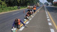 Sejumlah pekerja menyelesaikan pengecatan marka jalan di jalur pantura Widasari, Indramayu, Jawa Barat, Sabtu (16/4/2022).