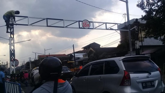 Petugas memperbaiki portal underpass Makamhaji.