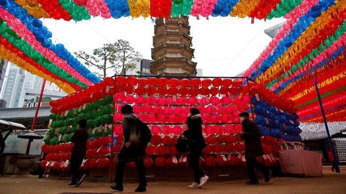 SOUTHKOREA-RELIGION/ A worker attaches prayer petitions to lotus lanterns in preparation for the upcoming birthday of Buddha at a temple in Seoul, South Korea, April 15, 2022. REUTERS/Kim Hong-Ji