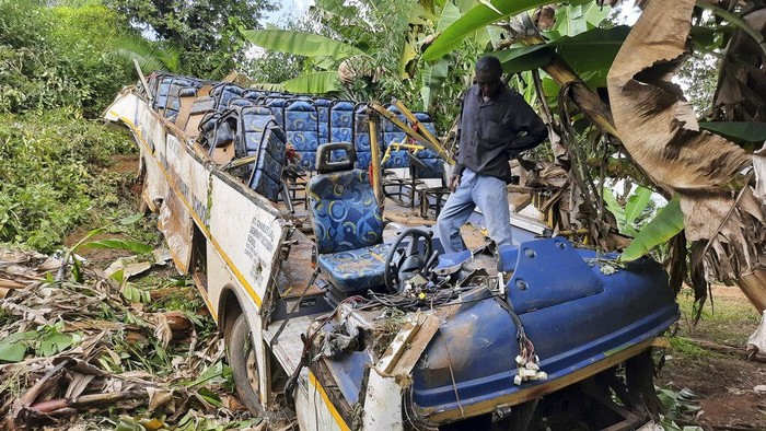 A man looks at the wreck of bus in a gorge after been involved in an accident near Chimanimani, the eastern part of Zimbabwe, Friday, April, 15, 2022. A bus carrying worshippers traveling to an Easter pilgrimage in mountainous eastern Zimbabwe plunged into a gorge, killing 35 people in the early hours of Friday. (AP Photo)