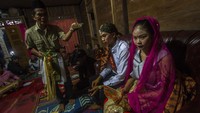 Penghulu melakukan prosesi batindik saat acara adat pernikahan dayak meratus di Dusun Pantai Mangkiling, Kabupaten Hulu Sungai Tengah, Kalimantan Selatan, Sabtu (16/4/2022) malam. 