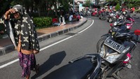 Antrean motor warga terlihat Kantor Perwakilan Bank Indonesia (BI) Provinsi Jawa Timur di Surabaya, Jawa Timur. Kondisi cuaca yang cukup panas membuat sejumlah warga berteduh sembari menunggu giliran menukarkan uang baru secara lantatur (layanan tanpa turun).