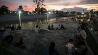 Warga duduk menikmati matahari terbenam di Taman Bendung Tirtonadi, Solo, Jawa Tengah, Rabu (6/4/2022). ANTARA FOTO/Mohammad Ayudha.