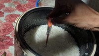 Begini jadinya jika ahli listrik disuruh masak nasi. Agar seluruh keluarga aman, nasi yang baru matang dites dulu dan dipastikan terbebas dari aliran listrik.Foto: 1cak.com